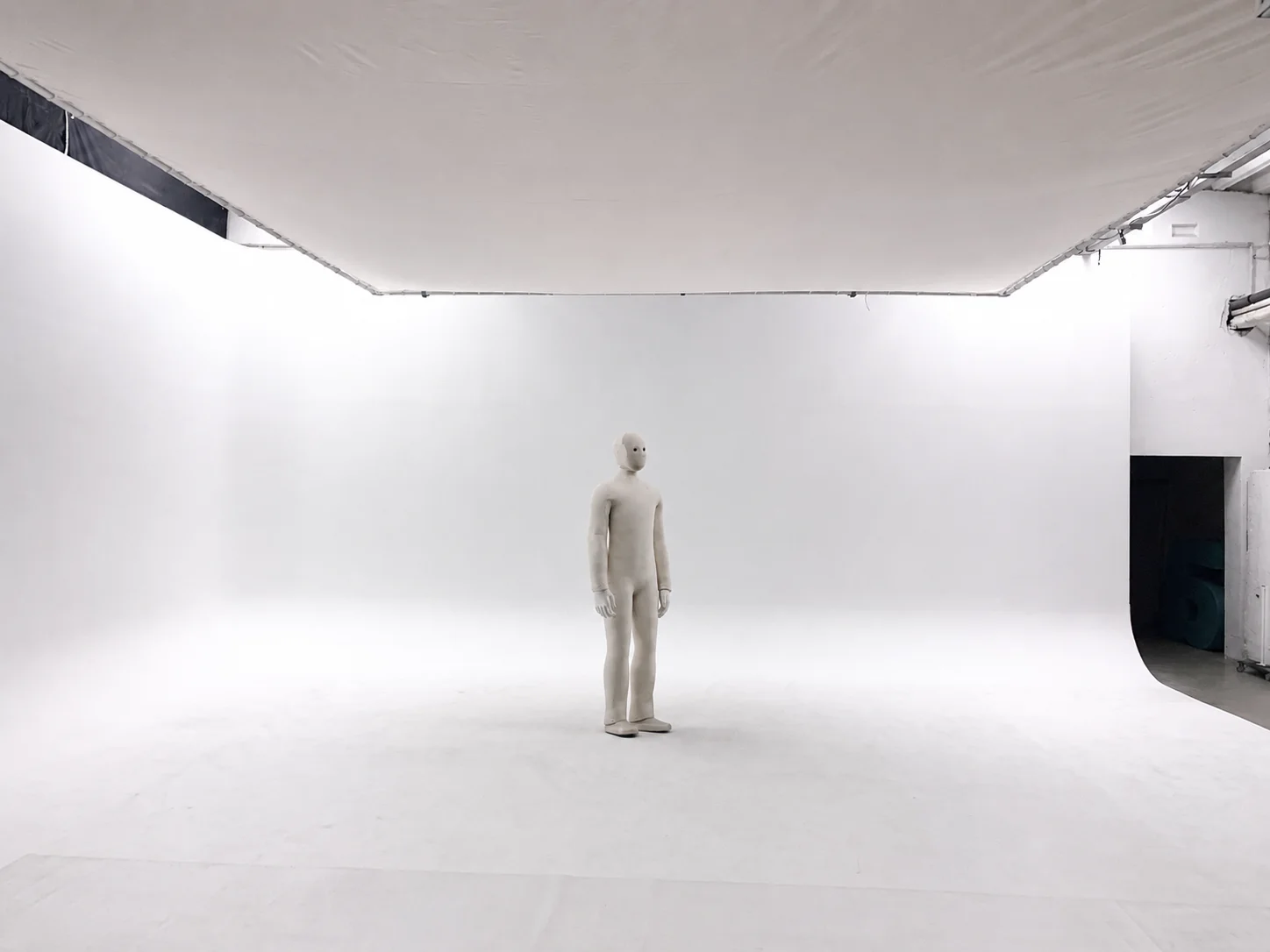 Weißer Roboter steht in minimalistischem Fotostudio mit heller Beleuchtung und weiße Hohlkehle.